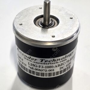 Close-up of a cylindrical DC motor with a vertical drive shaft and a silver bearing housing in the center of a metal top plate.