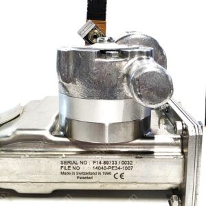 Close-up of a shiny metal mechanical part with a plate showing serial numbers and Made in Switzerland text.