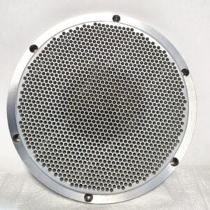 Close-up of a round metal grille with many small circular holes and screws around the edge, likely a vent or speaker cover.