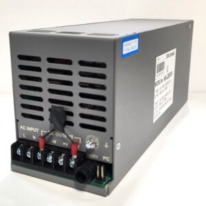 Gray metal power supply unit with vented sides; front terminal block and red jumpers visible, plus a side label with model number VA-26519