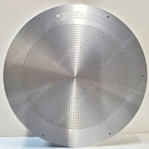 Close-up of a circular brushed-metal perforated plate (speaker/grill) with tiny evenly spaced holes and small mounting holes around the edge, text at top reads 'Made in Singapore'.