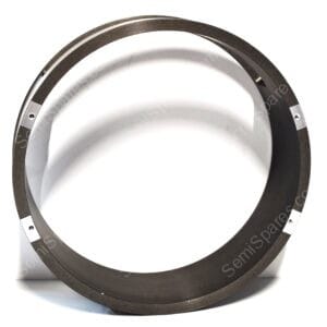 Close-up of a metal circular ring resting on a white surface, showing a smooth inner bore and outer scored edge with small screws/notches.