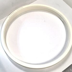 Close-up of a white ceramic plate rim resting on a white surface.