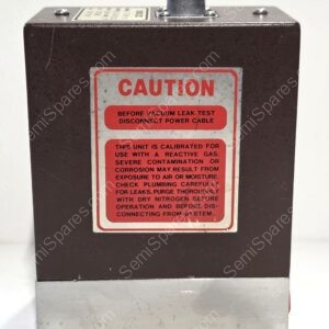 Close-up of a brown metal housing with a red caution label reading 'CAUTION' on the front panel.