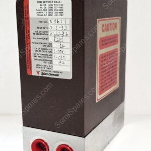 Calibration device with two red circular ports on a metal base and a brown housing with service and caution labels visible on the side.
