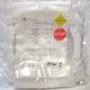 Clear plastic bag containing an Applied Materials certificate of compliance with yellow ATTENTION and red STOP stickers visible.