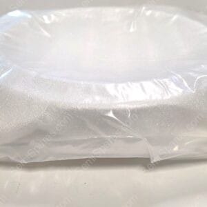 Close-up of a white object wrapped in clear plastic film on a light surface