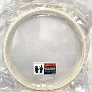 Close-up of a grey circular object wrapped in clear plastic with a safety label showing hand icons and an 'IMPORTANT' warning about keeping the part clean and using gloves.