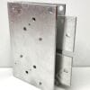 Close-up of a silver galvanized hinge block with multiple drilled holes and a connected bracket extending to the right.