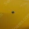 Small dark speck on a smooth yellow surface (likely a bit of debris).