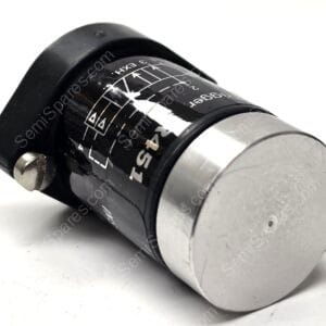 Close-up of a black camera lens focusing/adjustment dial with a silver base on a white surface, showing scale markings.