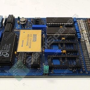 Blue vintage computer motherboard with gold edge connector and multiple DIP ICs, RAM sockets, and a yellow ADC converter module at center.