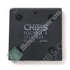 Close-up of a black integrated circuit chip with white alphanumeric markings and circular indentations on its surface.