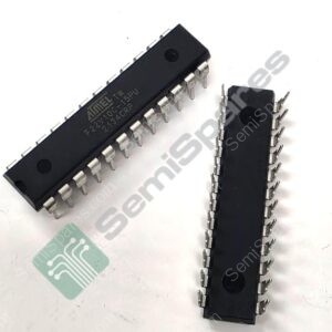 Two black DIP integrated circuit chips with metal pins laid on a white surface, viewed from an angle, showing their lead frames.