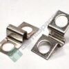 Close-up of shiny metal electrical lug connectors with circular holes, laid on a white surface