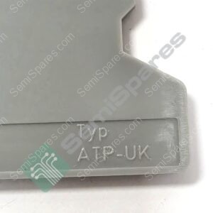 Close-up of a gray metal device with engraved text reading 'TYPE AT-PUK' and a green circuit-pattern sticker partially visible.