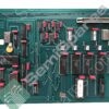 Vintage green circuit board with many DIP ICs, red capacitors, and edge connectors, showing dense electronics hardware.