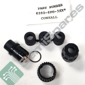 Close-up of black circular electrical connectors with exposed gold contacts on a white surface, near a PART NUMBER 6282-6PG-3XX CONXALL label.