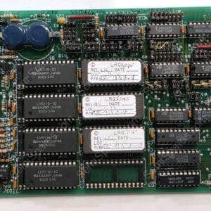 Green circuit board with many DIP ICs and a right-edge connector, plus a blue capacitor cluster on the left.