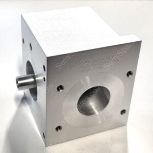 Silver metal block with multiple circular holes and threaded ports, seen from an angled side, showing precise machining marks.