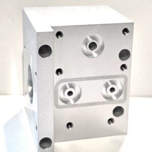 Aluminum machined block with multiple holes and threaded ports, including a central large bore area like a mounting plate.