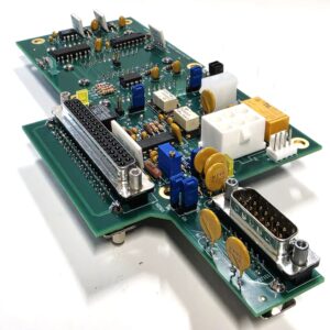 Close-up of a green printed circuit board with ICs, connectors, capacitors, and soldered components stored on a white background.