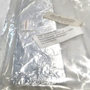 Close-up of a shiny foil-wrapped package inside a clear plastic bag, with a white label bearing a barcode partially visible.
