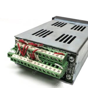 Close-up of a metal control module with a green terminal strip and numbered screw terminals with red and white wires connected.