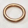 Copper wedding band ring on a light background, simple smooth design.