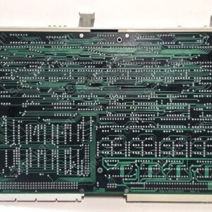 Rear view of a dense printed circuit board with many solder pads and green conductive traces, mounted in a gray chassis frame.