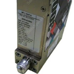 Metal industrial electronic module with a data label on its side and a knurled circular connector at the bottom front. The label appears to show manufacturing data (MFG DATA, Vishay Siliconix).