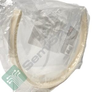 Clear plastic packaging around a light-colored item with a teal tag showing a white circuit-pattern design partially visible.