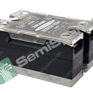 Close-up of a clear plastic lid over a black electronic block with printed text and a green circuit watermark nearby.