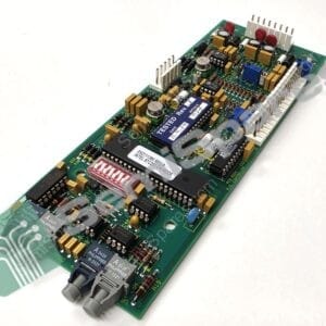 Angled close-up of a green printed circuit board with numerous capacitors, resistors, and connectors.