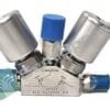 Close-up of a stainless steel Swagelok valve fitting with a blue cap and angled joints