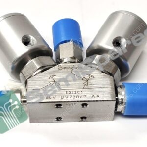 Close-up of a Swagelok valve assembly with blue caps and threaded ports at both sides.